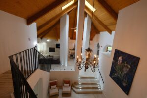 Open concept interior with vaulted wood beam ceiling and staircase photographed in San Diego