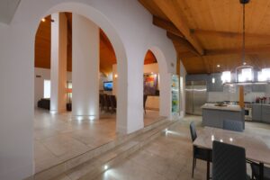 Open concept kitchen with stainless steel appliances and wood beam ceiling photographed in San Diego
